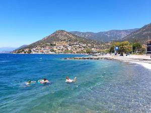 three people swimming in the water at a beach at Glyfada's Family Apartment in Glyfada Fokidas