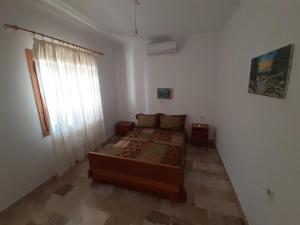 a bedroom with a large bed and a window at Glyfada's Family Apartment in Glyfada Fokidas