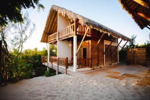 a house with a thatch roof and a balcony at Chalet du Kite in Prea