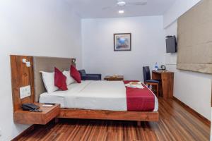 a hotel room with a bed and a desk and a bed sidx sidx at J Hotel and Banquets in Mumbai +37 photos