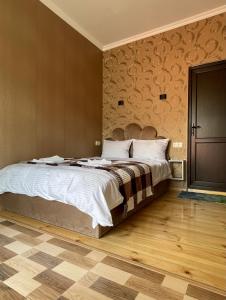 a bedroom with a large bed and a wooden floor at Sunny guesthouse in Kazbegi
