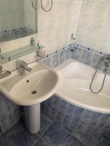 ein Badezimmer mit einem Waschbecken und einer Badewanne in der Unterkunft REAL Tashkent in Taschkent