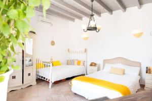 two beds in a bedroom with white walls at Kimolos in Sikinos