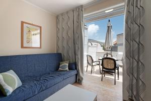 a living room with a blue couch and a patio at Apartment Colina Vista in Los Cristianos