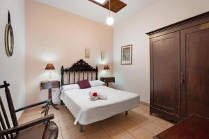a bedroom with a bed and a wooden cabinet at Casa Barreto in Puerto de la Cruz