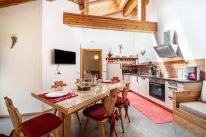 a kitchen and dining room with a wooden table and chairs at Ferienhaus Larch Soge Apt Paula in Racines