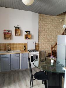 a kitchen with a table and a stove at Maison calme in La Réole