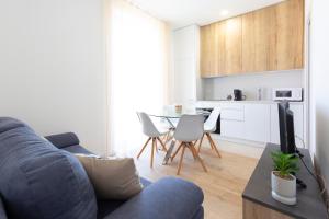 uma sala de estar com um sofá azul e uma cozinha em MARNE I - 2 PIÈCES - CARRÉ D'OR Menton em Menton