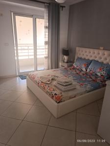 a bedroom with a bed with a large window and a bed sidx sidx at Marinela Apartment in Sarandë