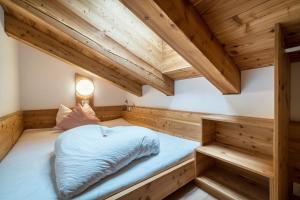 a bed in a room with wooden ceilings at Ferienhaus Larch Soge Apt Helmuth in Racines