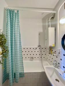 baño con cortina de ducha azul y lavamanos en Nosztalgia Apartman en Veszprém