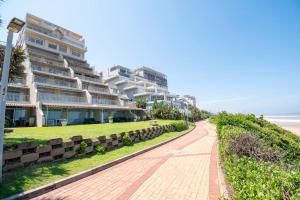 a sidewalk next to a large building on the beach at 26 Bronze Bay Umhlanga Rocks in Durban