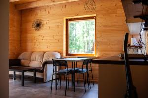 a living room with a couch and a table and chairs at Domek pod Chełmową Górą in Krasnobród