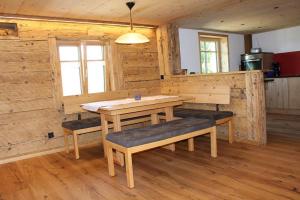 uma sala de jantar com uma mesa e bancos numa cabina em Panoramahof Monika Kennerknecht em Akams