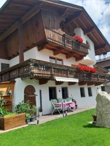 uma casa com uma varanda com flores vermelhas em Apartment Rahm em Gerlosberg