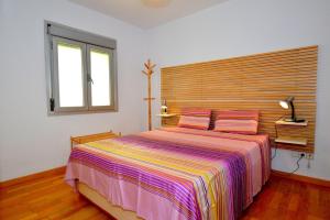 Schlafzimmer mit einem großen Bett mit einem Kopfteil aus Holz in der Unterkunft Coqueto apartamento a pocos metros de playa in Can Pastilla