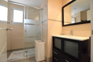 uma casa de banho com um chuveiro, um lavatório e um espelho. em Coqueto apartamento a pocos metros de playa em Can Pastilla