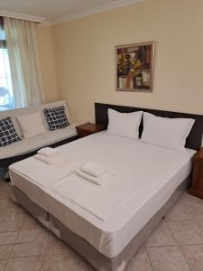 ソゾポルにあるApartments in Sveta Marina Holiday Villageのベッドルーム(大きな白いベッド1台、ソファ付)