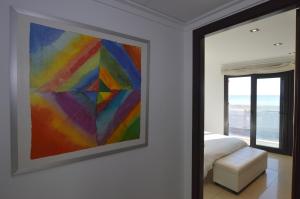 una pintura colorida en una pared en un dormitorio en Apartamento delante del mar en Can Pastilla