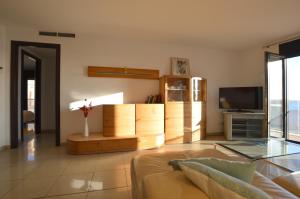 a living room with a couch and a television at Apartamento delante del mar in Can Pastilla
