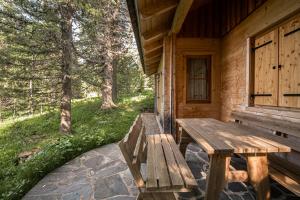 eine Holzbank auf der Veranda einer Hütte in der Unterkunft Alpin-Hütten auf der Turracherhöhe Haus Murmeltier by S4Y in Turracher Hohe