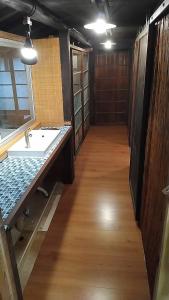 a bathroom with a sink and a wooden floor at Momiji hostel in Minami Aso