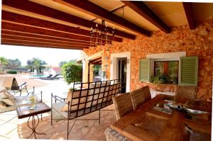 eine Terrasse mit einem Tisch und Stühlen sowie ein Gebäude in der Unterkunft Casa con piscina en bonito entorno Mia in Costitx
