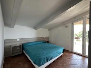 ein Schlafzimmer mit einem Bett und einem großen Fenster in der Unterkunft Appartamento Santa Lucia E in Policastro Bussentino