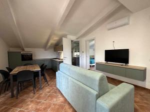 ein Wohnzimmer mit einem Sofa, einem Tisch und einem TV in der Unterkunft Appartamento Santa Lucia E in Policastro Bussentino