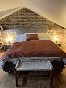 een slaapkamer met een bed en een bakstenen muur bij Le GYPSY - CHARME & EMPLACEMENT PARFAIT in Honfleur