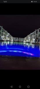 uma piscina azul em frente a um edifício à noite em Perla Andaloussia em Minaret de Mansuria
