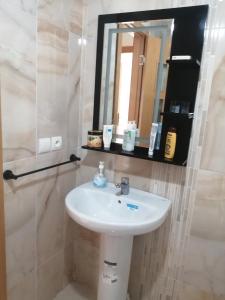 uma casa de banho com um lavatório e um espelho em Perla Andaloussia em Minaret de Mansuria