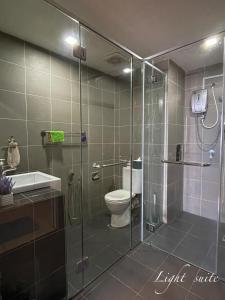 a bathroom with a shower with a toilet and a sink at Chill Studio Wi-Fi & Netflix 5min From Airport At Aeropod Sovo in Kota Kinabalu