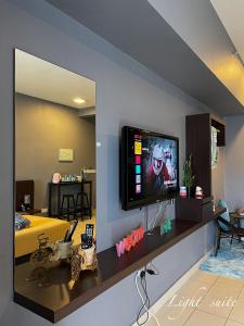 a living room with a flat screen tv on a wall at Aeropod Sovo Wi-Fi&Netflix 5min From Airport in Kota Kinabalu