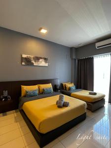 two beds in a hotel room with yellow sheets at Aeropod Sovo Wi-Fi&Netflix 5min From Airport in Kota Kinabalu