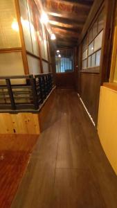 um corredor vazio de um edifício com piso de madeira em Momiji hostel em Minami Aso