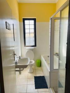 ein Bad mit einem WC, einem Waschbecken und einer Dusche in der Unterkunft 3 Bedroom, 3 Bathroom, Close to the Beach & Town in Swakopmund