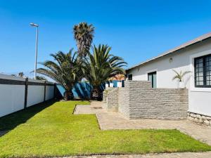 a house with palm trees and a fence at 3 Bedroom, 3 Bathroom, Close to the Beach & Town in Swakopmund