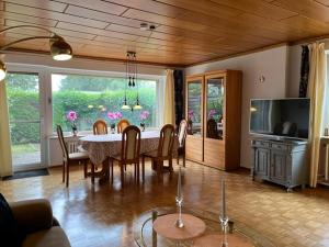 a dining room with a table and chairs and a television at Nord Haus in Kiel