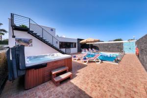 a house with a hot tub and a swimming pool at Villa Aurelia - Pool, Jacuzzi, BBQ and Ping-Pong By Lanzarote Vacation Homes in Playa Blanca