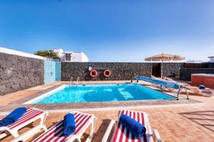 una piscina con due sedie a sdraio e una piscina di Villa Aurelia-pool, jacuzzi and solarium a Playa Blanca