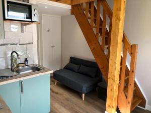 a kitchen with a couch and a staircase in a room at Ene Breizhad in Arzon