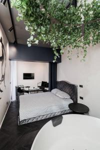 ein Schlafzimmer mit einem Bett mit Pflanzen an der Wand in der Unterkunft Butas su Jacuzzi Kauno miesto centre in Kaunas