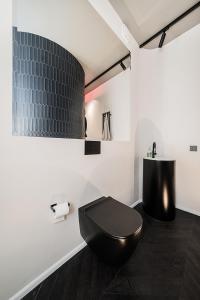 ein Bad mit einem schwarzen WC in einem Zimmer in der Unterkunft Butas su Jacuzzi Kauno miesto centre in Kaunas