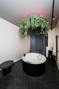 Zimmer mit einer Badewanne mit Pflanzen an der Wand in der Unterkunft Butas su Jacuzzi Kauno miesto centre in Kaunas