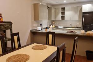 a kitchen with a table and chairs and a counter at Aeon Towers Luxury Apartment in 6th Of October