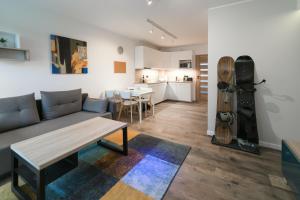 una sala de estar con un sofá y una mesa en Apartamenty Nad Żylicą przy deptaku - Dream Apart, en Szczyrk