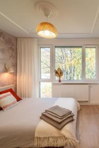 Un dormitorio con una gran cama blanca y ventanas. en Apartament Fala Metro SGH Klub Stodoła Parking Parkview Fast Wifi, en Varsovia
