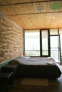 a bedroom with a bed and a stone wall at Gnishik Eco Lodge in Gnishik