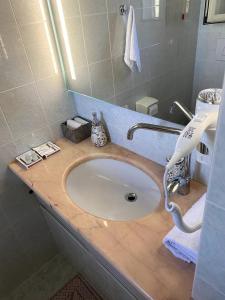 un bancone del bagno con lavandino e specchio di Mini Red Hub - Design Apartment a SantʼAgapito
